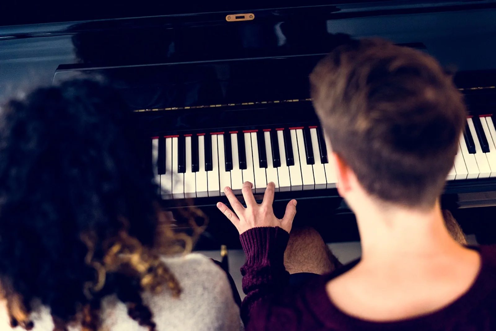 Zwei Menschen musizieren gemeinsam am Klavier